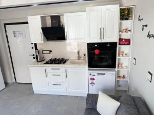 a kitchen with white cabinets and a white refrigerator at Erdem Apart8 in Dalaman