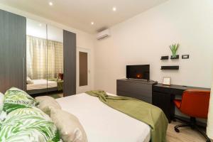 Un dormitorio con una cama, un escritorio y un televisor. en Appartamento Green House, en Turín