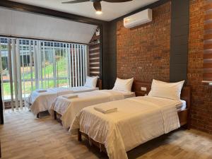 Habitación con 3 camas y pared de ladrillo en Sunrise Villa Genting, en Bentong 52 fotos más