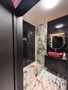 a bathroom with a red sink and a mirror at Apartament Diament 2 in Człuchów