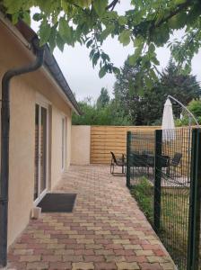 a patio with a bench next to a fence at Gîte de l'écluse carrée in Coulogne