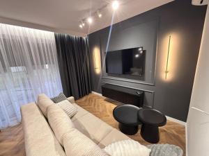 a living room with a couch and a tv at Apartament Diament 2 in Człuchów