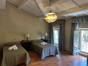 a bedroom with two beds and a chandelier at Hotel Villa dei Pini in San Terenziano +90 photos