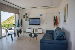a living room with a blue couch and a table at Maison Margot in Forio d'Ischia