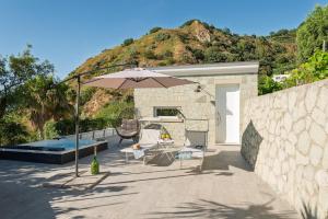 a patio with a table and an umbrella at Maison Margot in Forio d'Ischia