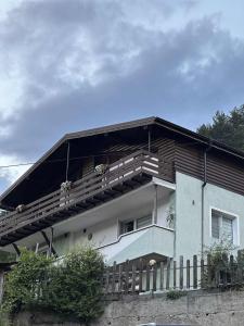 a building with a balcony with flowers on it at Къща за гости Шанови in Gʼovren