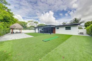 a house with a large lawn in front of it at 5 Mi to Delray Public Beach Home with Large Patio! in Delray Beach