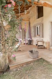 a room with a wooden deck with flowers on it at Au Clair de Vianne Ce sont les petits détails qui font la différence in Vianne