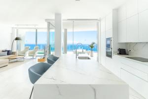 une cuisine blanche avec un grand comptoir blanc dans l'établissement Crystal I Luxury Apartments by Hermosa Rentals, à Acantilado de los Gigantes