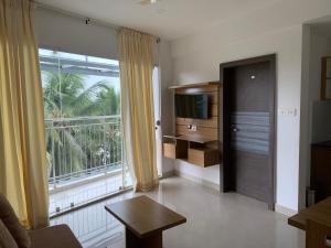 a living room with a large window and a television at Lilly Ribera in Kumarakom