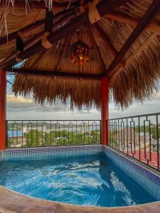 a swimming pool in a resort with a thatched roof at Bacanda Hotel in Puerto Escondido