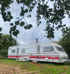 a red and white trailer parked in a field at Tornio caravan in Tornio
