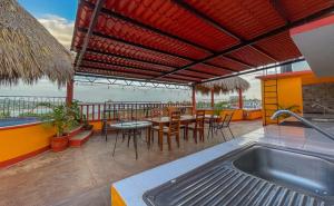 an outdoor patio with a table and chairs and a sink at Bacanda Hotel in Puerto Escondido