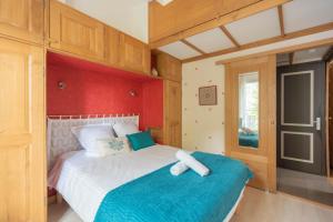 a bedroom with a large bed with a blue blanket at Au Petit Bonheur Proche Centre et Lac in Aix-les-Bains