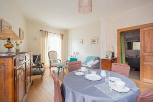 a dining room with a table and a living room at Au Petit Bonheur Proche Centre et Lac in Aix-les-Bains