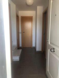 Un pasillo vacío con una puerta y un suelo de baldosas. en Casa Rural Pozo, en San Nicolás del Puerto