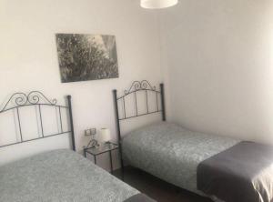 Un dormitorio con dos camas y un cuadro en la pared. en Casa Rural Pozo, en San Nicolás del Puerto