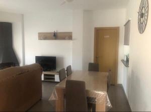 Una sala de estar con una mesa y un televisor. en Casa Rural Pozo, en San Nicolás del Puerto