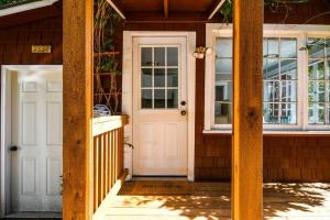una casa con porta bianca e finestre di Adorable Cottage Among Trees Close To Everything a Vancouver