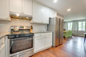 a kitchen with white cabinets and a stainless steel refrigerator at Inviting Home with Backyard 8 Mi to Dtwn Atlanta! in Atlanta