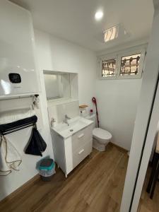 a white bathroom with a toilet and a sink at Chaleureux Studio Tout Confort in Orléans