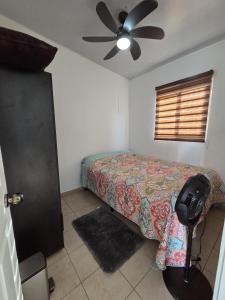 een slaapkamer met een bed en een plafondventilator bij The terrazzo house in Santa Ana