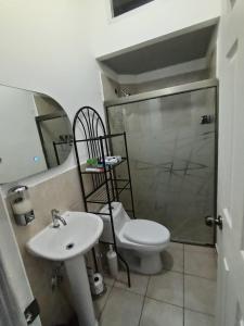 een badkamer met een toilet, een wastafel en een douche bij The terrazzo house in Santa Ana +7 foto's
