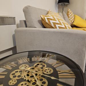 a couch and a clock in a living room at Birmingham City Centre Apartment Near New Street Station The Cube Mailbox Brindley Place Ace Apartment in Birmingham