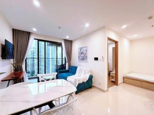 a living room with a blue couch and a table at Shi House - Modern Apartment Vinhomes Grand Park - Căn Hộ 1PN in Gò Công
