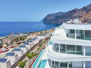 une vue aérienne d'un bâtiment à côté de l'océan dans l'établissement Crystal I Luxury Apartments by Hermosa Rentals, à Acantilado de los Gigantes