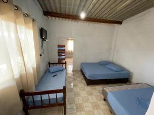 a room with two beds and a tv in it at recanto da basílica in Aparecida