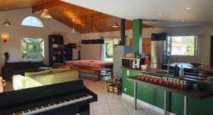 a kitchen with a piano and a living room at Lou barede in Montagne