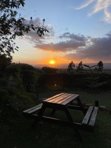 a picnic table with the sunset in the background at Couple's Wood Cabin in Naivasha - Elwai Visitor Centre in Naivasha