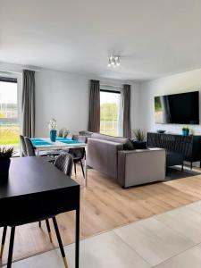 a living room with a couch and a table at Baltic Spot Apartment Letnica in Gdańsk