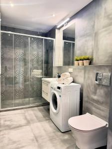 a bathroom with a washing machine and a toilet at Baltic Spot Apartment Letnica in Gdańsk