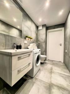 a laundry room with a washing machine and a sink at Baltic Spot Apartment Letnica in Gdańsk +2 photos