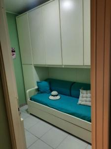 a blue couch with white cabinets and a hat on it at Casa Vacanza Azzurra in Casal Palocco