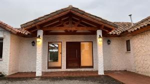 una casa con puerta de madera y techo en Los laureles limache, 