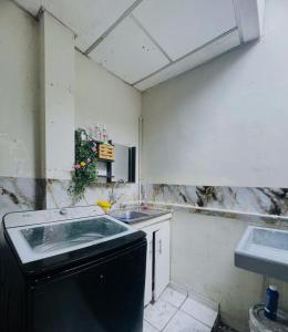 eine schmutzige Küche mit Spüle und Geschirrspüler in der Unterkunft Hostal 5224 in San Salvador