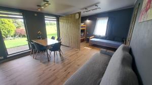 a living room with a couch and a table and chairs at Guest House Podnieki in Ventspils