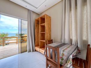 a bedroom with a bed and a balcony at Loft Sol e Mar Exclusivo em Bombinhas 50m da praia in Bombinhas