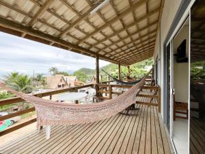 a hammock on the balcony of a house at Loft Sol e Mar Exclusivo em Bombinhas 50m da praia in Bombinhas