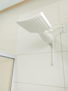 a bathroom with a shower head on the wall at Loft Sol e Mar Exclusivo em Bombinhas 50m da praia in Bombinhas +20 photos