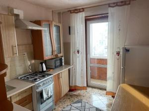 a small kitchen with a stove and a window at Ліор in Lviv