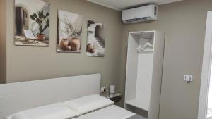 ein Schlafzimmer mit einem Bett mit vier Bildern an der Wand in der Unterkunft Reitano House in Catania