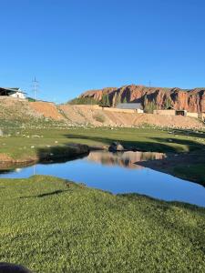 uitzicht op een golfbaan met een vijver bij Eco house in Naryn