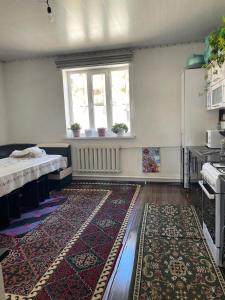 een keuken met een tapijt op de vloer en een raam bij Eco house in Naryn +5 foto's