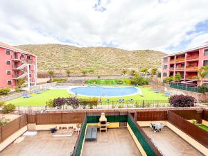 an apartment patio with a pool and a park at Little Palmar with Free Parking & Pool & Padel in Palm-Mar
