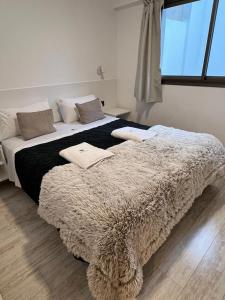 a bedroom with a large bed with a blanket at XV Apartamentos in La Plata +40 photos