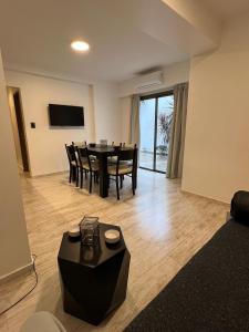 a living room with a table and chairs and a television at XV Apartamentos in La Plata